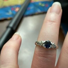 a close up of a person's hand with an engagement ring on their finger