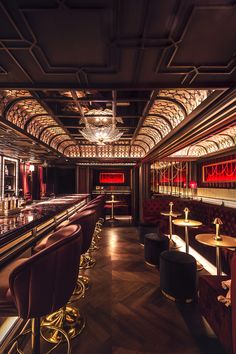 a dimly lit bar with red and gold chairs