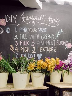 flowers are lined up in front of a chalkboard