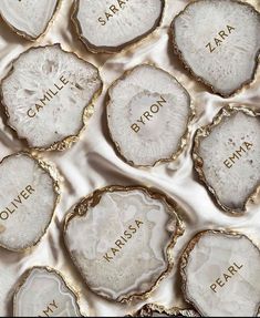 several pieces of white agate with gold lettering on them, all in different shapes and sizes