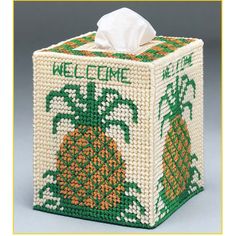 a white tissue box with green and orange pineapples on it