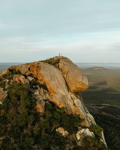 a person standing on top of a large rock