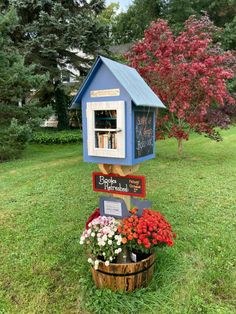 a blue birdhouse with flowers in the yard