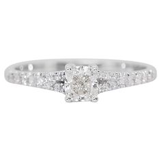 a white gold ring with an oval cut diamond in the center and pave set shoulders