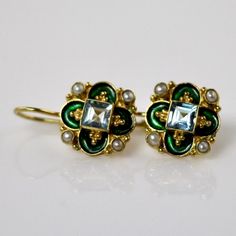 This unique Arts & Crafts Movement design showcases an onyx, iolite, blue topaz, emerald, or garnet set in a cloverleaf of emerald-green or royal blue enamel work, accented with cultured pearl. 24k gold over sterling silver. European back for pierced ears. Size: 3/4 inch. Movement Design, Flowers Jewelry, Lapis Earrings, Big Jewelry, Historical Jewellery, Sparkly Things, Laurel Burch, Garnet Earrings, Hand Made Jewelry