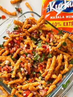 a glass bowl filled with fried food next to a bag of kfc's masala munchies