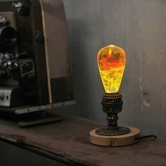 a yellow light bulb sitting on top of a wooden table next to a microwave oven