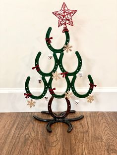 a christmas tree made out of horseshoes on a wooden floor