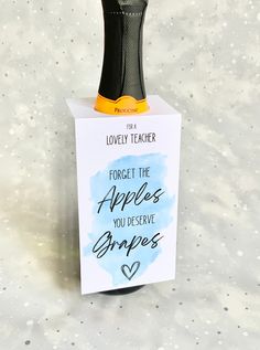 a bottle of wine sitting on top of a card with a note attached to it