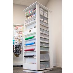 a large white shelf filled with lots of crafting supplies on top of a carpeted floor