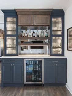 a kitchen with gray cabinets and an icebox in the center is filled with drinks