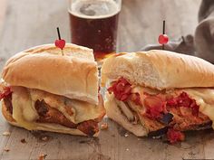 two sandwiches cut in half sitting on top of a cutting board