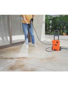 a person using a pressure washer to clean concrete