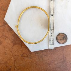 24KT yellow gold-plated + sterling silver replica Roman coin bangle with diamond. Double-sided silver coin set with textured, matte finish to the gold bangle! Length: 7" approx. Diameter: 60mm Band width: 2mm Weight: 11.80 grams (1) .01 CT natural, round diamond 21mm round replica coin Hook style clasp 925 sterling silver purity with 24KT gold plating Classic Hammered Adjustable Jewelry, Classic Adjustable Hammered Jewelry, Adjustable Yellow Gold Hallmarked Cuff Bracelet, Gold-plated Round Cuff Bracelet, Classic Hammered Bracelet Jewelry, Adjustable Hammered Yellow Gold Bracelet, Adjustable Yellow Gold Hoop Bracelet, Hammered Yellow Gold Bangle Bracelet, Yellow Gold Metal Cuff Bracelet