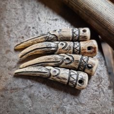 four carved wooden knives sitting on top of a stone floor next to a knife blade