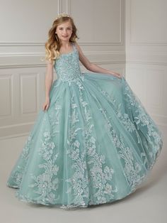 Your sweet girl will make a grand entrance in this beaded floral applique long sleeveless dress with A-line tulle skirt by Tiffany Princess 13720. This sleeveless gown features a scoop neck bodice with beaded floral lace appliques, A-line glitter tulle skirt, sweep train, and a lace-up back. House of Wu Tiffany Princess Collection Fall 2023 Style Number: 13720 Fabric: Beaded Floral Appliques/Tulle Please note: There may be a loss of glitter while wearing this dress due to the nature of the fabri Pageant Dress With Floral Applique And Fitted Bodice, Sleeveless Pageant Dress For Prom Season, Sleeveless Pageant Dress With Sheer Bodice, Princess Style Sleeveless Pageant Dress With Fitted Bodice, Sleeveless Gown With Sheer Bodice For Pageants, Princess Style Pageant Dress With Sheer Bodice, Princess Style Dress With Sheer Bodice For Pageant, Sleeveless Tulle Pageant Dress With Fitted Bodice, Fitted Sleeveless Pageant Dress With Lace Bodice