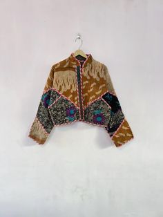 a jacket hanging on a white wall with an orange and blue pattern in the middle