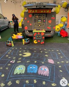 a chalk drawing on the ground next to some toys and people standing in front of it