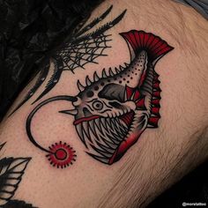 a man's leg with a tattoo on it that has a fish and spider web