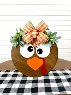 a wooden turkey with a bow on it's head sitting on top of a table