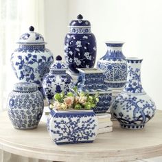 a table topped with lots of blue and white vases