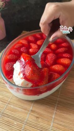 someone is scooping strawberries into a bowl with ice cream on the top and bottom