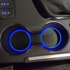 the interior of a car with two speakers and blue lights on it's center console