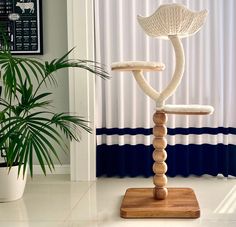 a white chair sitting on top of a wooden stand next to a potted plant