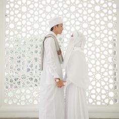 two men dressed in white standing next to each other