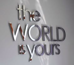 the word'the world is yours'written in cut out letters on a wall