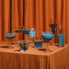 a table topped with lots of glasses filled with different colored liquids and liquids next to each other