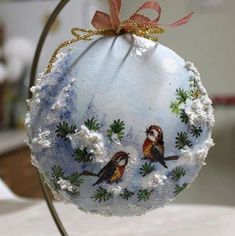 a glass ornament with two birds on it