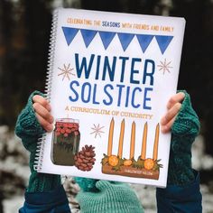 a person holding up a book about winter solstice