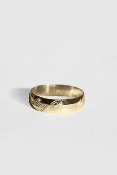 a gold ring with the word love written on it and a diamond in the middle