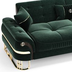 a green velvet couch with gold trimmings on the arms and back, sitting in front of a white background