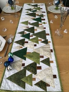 the table runner is decorated with green and white christmas trees