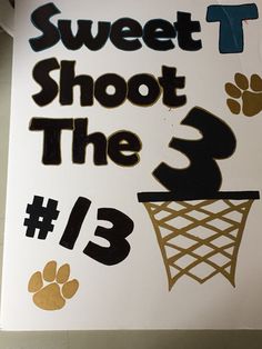 there is a sign that says sweet shoot the 3 with paw prints and a basketball hoop