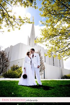 a man and woman are standing in front of a church