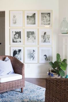 a living room with pictures on the wall and a wicker chair in front of it