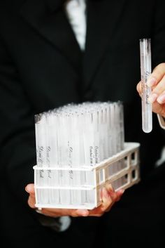 a person in a suit holding some plastic tubes