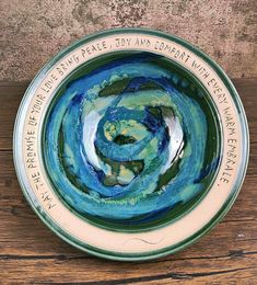 a blue and green bowl sitting on top of a wooden table