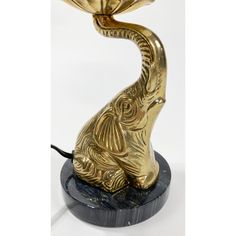 a golden elephant lamp sitting on top of a black base