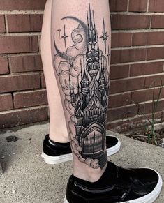 a woman's leg with a castle tattoo on it