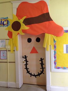 a door decorated to look like a scarecrow with a hat and sunflower on it