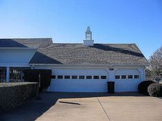 a large white house with a clock tower on the top of it's roof