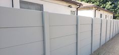 a long white fence next to a house