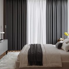 a bedroom with black and white curtains, grey drapes, and a large bed in front of a window