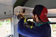 a man is working on the side of a bus