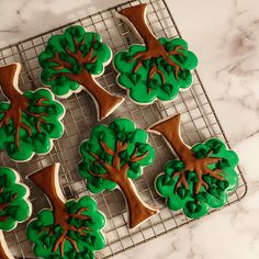 cookies decorated with green and brown trees on a cooling rack