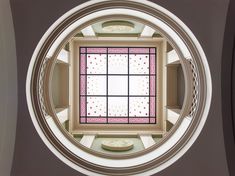 a circular window in the center of a room with white and pink decorations on it